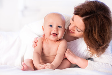 Mother and baby on a white bed