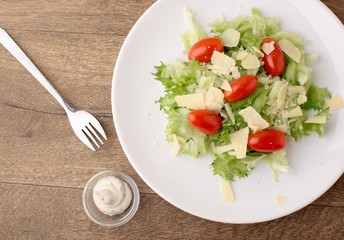 Fresh salad parmesan on a wooden background