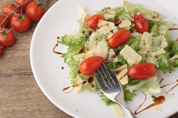 Fresh salad parmesan on a wooden background