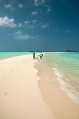 Fototapeta na wymiar Couple walking in a maldivian island