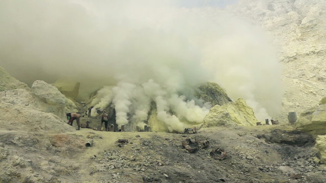 Ijen volcano crater, workers dig sulfur in extreme conditions, slow motion

