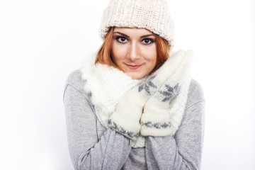 Young girl in a woolen hat and scarf. A girl dressed warmly. Winter cold. Portrait of a girl with big eyes on a white background
