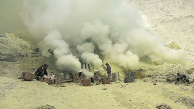 Ijen volcano crater, workers dig sulfur in extreme conditions, slow motion
