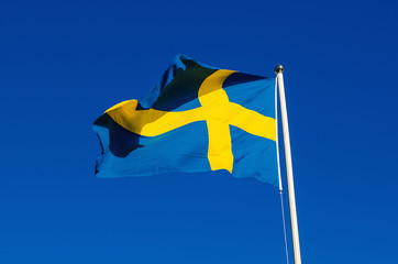 Flag of Sweden against the blue sky, national patriotic background