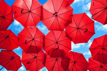 Lots of red umbrellas coloring the sky in the city center