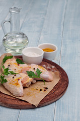 raw chicken wings with curry seasoning, oil, parsley and pepper
