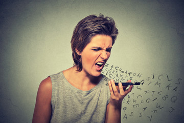 Portrait angry young woman screaming on mobile phone
