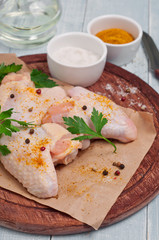raw chicken wings with curry seasoning, parsley and pepper