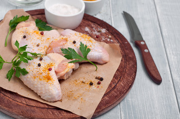 raw chicken wings with curry seasoning, parsley and peppe