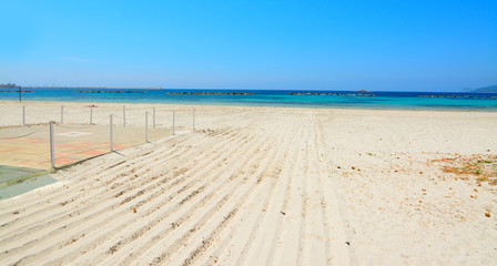 Fototapeta na wymiar white sand and blue water in Alghero sea shore