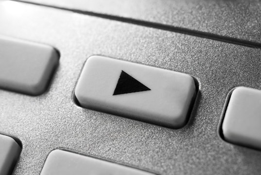 Macro Of A Grey Play Button On Chrome Remote Control For A Hifi Stereo Audio System