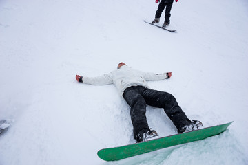 Snowboarder lying prone in the winter snow