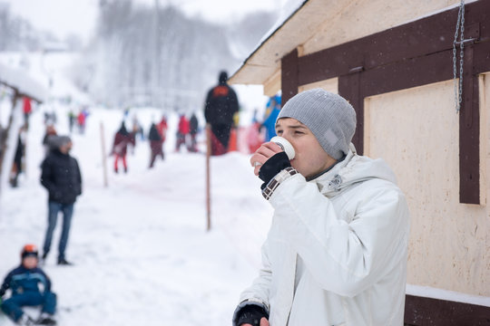 Young man drinking coffee at a ski resort