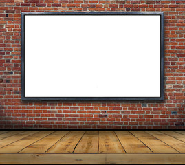One big blank billboard attached to a brick wall inside with wooden floor