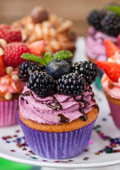 Delicious cupcake decorated with blueberry and blackberries