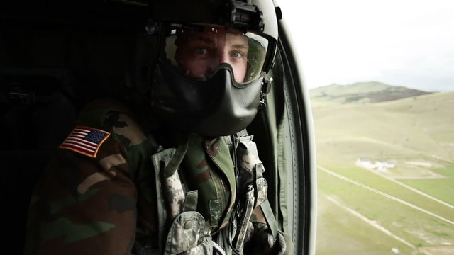 Soldier gazing out of helicopter door