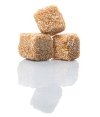 Brown sugarcane sugar cube over white background