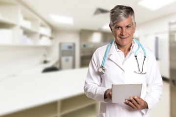 Doctor checking patient notes on a tablet-pc standing with his s