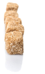 Brown sugarcane sugar cube over white background