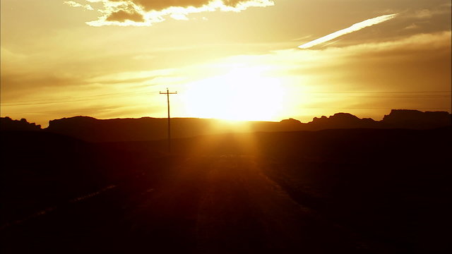 Time-lapse of the sun setting behind desert mountains.