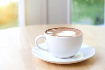 heart symbol on latte coffee cup on table