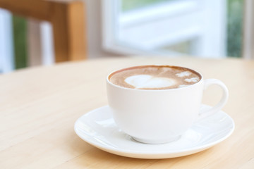 heart symbol on latte coffee cup on table