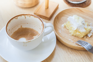 empty cup of coffee and soiled cake plate on  table