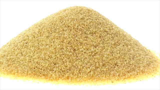 Vertical pan of fine coarse bulgur on white background.