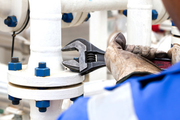 Close-up image of human hand fixing and stop leak flange by wrench in oil and gas process