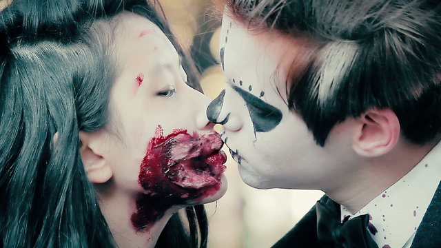Young man and woman with terrible bloody makeup looking aggressively into camera
