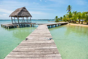 Long wooden walkway on the water of Caribbean sea on Bocas del Toro in Panama - obrazy, fototapety, plakaty