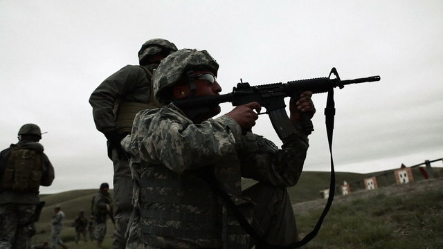 Kneeling soldier being instructed at range