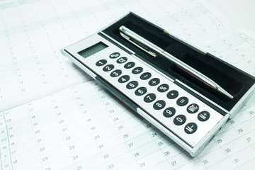 Pocket calculator and pen on the table