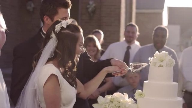 Newlywed couple cutting a traditional layered wedding cake, romantic lifestyle.