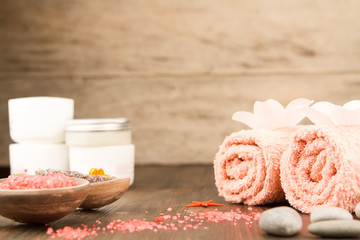 Spa composition with towels, sea salt on wooden background. Aromatherapy.