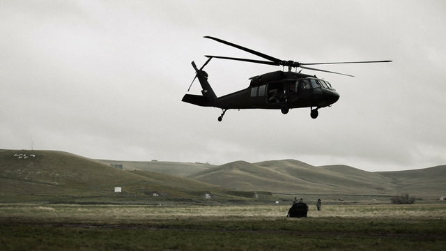 Black Hawk dropping cargo and flying off.