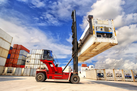 forklift handling the reefer container box at dockyard