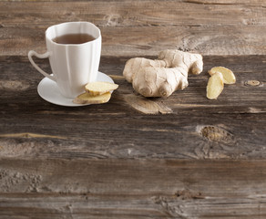 Ginger tea in a white cup on wooden background