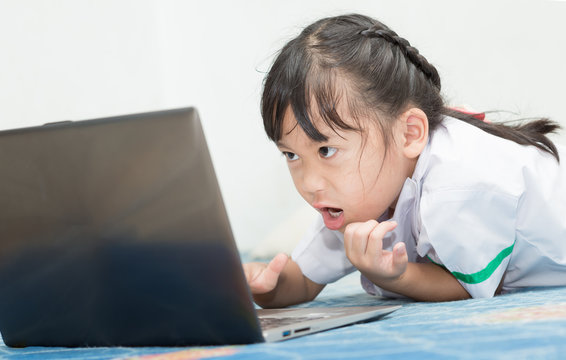 girl playing or working on a laptop computer