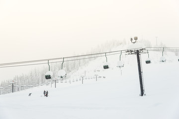 scene of ski lift with seats  over the mountain and paths from skier.