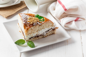 Cream cake with a cup of coffee and jar