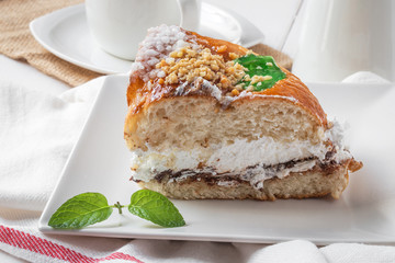 Cream cake with a cup of coffee and jar