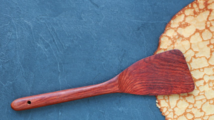 Crêpe sur fond en ardoise avec spatule en bois...carte, menu