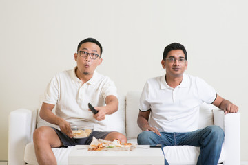 Men watching live sport game on tv together