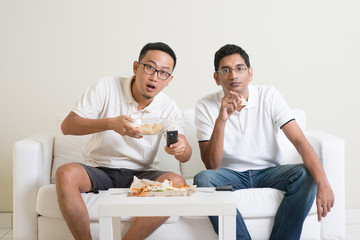 Men friends watching sport match on tv together