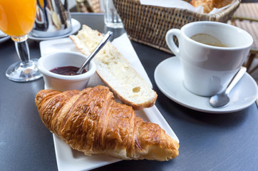 Breakfast with coffee and croissants on table