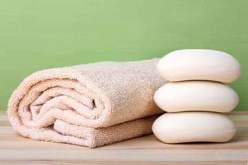 fragrant white soap and towel on wooden background