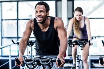 Fit man working out at spinning class
