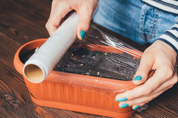 Women's hands with bright manicure is covered of plastic wrap se