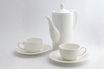 A white coffee pot and a cup